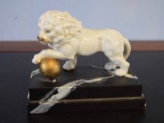 European model of a lion with a gilded ball resting underneath its front left foot, together with