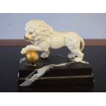 European model of a lion with a gilded ball resting underneath its front left foot, together with