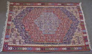 Wool embroidered Caucasian type carpet, central panel with pale blue lozenge and further red, blue