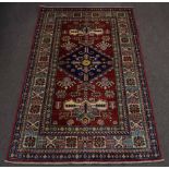 Late 20th century Caucasian small rug, mutli-gull border, central panel of blue lozenge, mainly red,