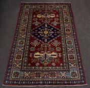 Late 20th century Caucasian small rug, mutli-gull border, central panel of blue lozenge, mainly red,