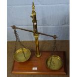 Set of vintage brass beam scales on a mahogany plinth, 48cm wide
