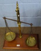 Set of vintage brass beam scales on a mahogany plinth, 48cm wide