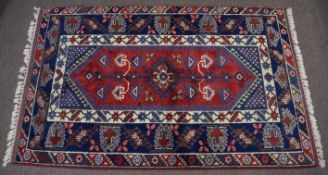 Thick pile Caucasian wool rug, triple gull border, central panel of geometric designs, mainly red,