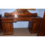 Large 19th century mahogany twin pedestal break front sideboard, pediment carved with foliate
