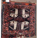 Caucasian camel bag decorated on one side with geometric designs on a mainly dark blue and puce