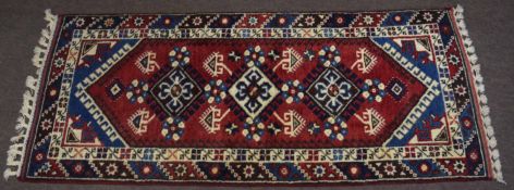 Caucasian small runner, double gull border, central panel of geometric lozenges, mainly red and blue