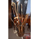 Vintage carved wood pail containing a collection of mainly modern walking sticks and canes including