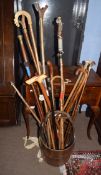 Vintage carved wood pail containing a collection of mainly modern walking sticks and canes including