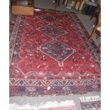 Large Shiraz type carpet, central panel with three interlinked lozenges, mainly red field, 2.94 x