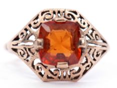 Yellow metal citrine set ring, the pierced scroll mount cardinal set with a square faceted