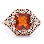 Yellow metal citrine set ring, the pierced scroll mount cardinal set with a square faceted