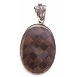 Antique mourning locket of oval form, glazed both sides with a plaited hair panel, engrave leaf