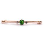 Green stone and diamond brooch, the centre oval faceted stone flanked by 2 small old cut diamonds,