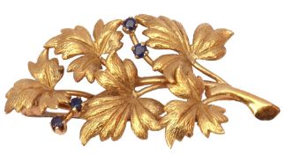 18ct gold and sapphire spray leaf brooch, the textured leaves highlighted with four small round