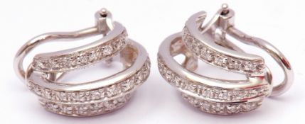 Pair of diamond set hoop shaped earrings, a stylised design featuring three bands, each set with a