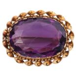 Amethyst pendant/brooch, the oval faceted amethyst 2 x 1.5cm, framed in a yellow metal scroll and