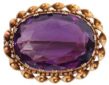 Amethyst pendant/brooch, the oval faceted amethyst 2 x 1.5cm, framed in a yellow metal scroll and