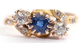 Late Victorian sapphire and diamond cross over ring, the centre a round cut faceted sapphire between