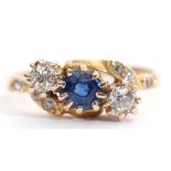 Late Victorian sapphire and diamond cross over ring, the centre a round cut faceted sapphire between