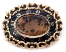 Victorian mourning brooch, the oval centre a moss agate panel on a black surround decorated with