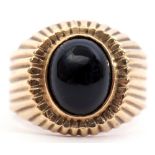 15ct stamped onyx ring, the oval shaped cabochon set in a part engraved engraved reeded mount,