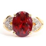 Modern garnet and diamond dress ring, the oval faceted garnet raised between diamond pierced