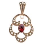 A 9ct gold garnet and seed pearl open work pendant, centring a collet and millegrain set oval