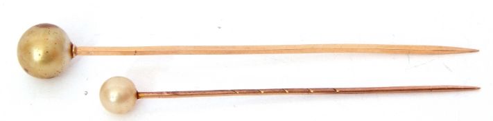Two yellow metal and simulated pearl stick pins, cased