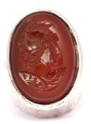 White metal framed intaglio ring, the oval hard stone reverse carved with a profile of a
