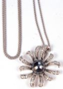 A modern 750 stamped diamond and black pearl pendant, the centre black Tahitian split pearl within