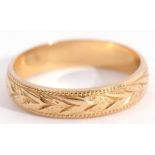 Wedding ring, stamped 750, engraved with a continuous foliate design between beaded edges, size K,