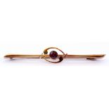 15ct stamped garnet bar brooch, the garnet in a scroll design on a knife edge bar, safety pin catch,