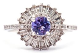 Tanzanite and diamond cluster ring, the central round faceted shaped tanzanite raised within a