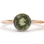 Early 20th century single stone peridot ring, a round faceted peridot, with rub-over set to a looped