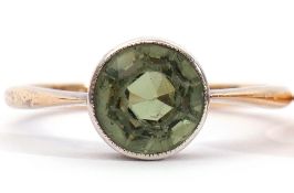 Early 20th century single stone peridot ring, a round faceted peridot, with rub-over set to a looped