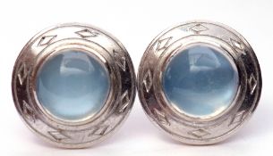 Pair of moonstone earrings, the circular cabochon moonstones framed in an engraved mount, the