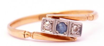 18ct stamped sapphire and diamond ring of cross over design, the central round faceted sapphire