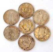 Assortment of seven American silver dollar coins dated 1923, 1922, 1921, 1922, 1922, 1922, 1922 (7)