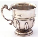 George V silver mug of baluster form, the lower portion applied with alternating strap-work designs,