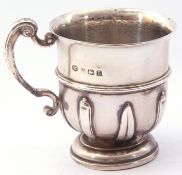 George V silver mug of baluster form, the lower portion applied with alternating strap-work designs,