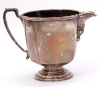 George V silver cream jug of circular panelled form, capped leaf scroll handle reeded borders, the