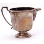 George V silver cream jug of circular panelled form, capped leaf scroll handle reeded borders, the