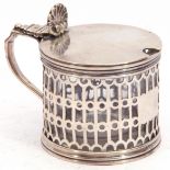 Victorian silver mustard with circular body pierced, grill design, the hinged lid with shell thumb