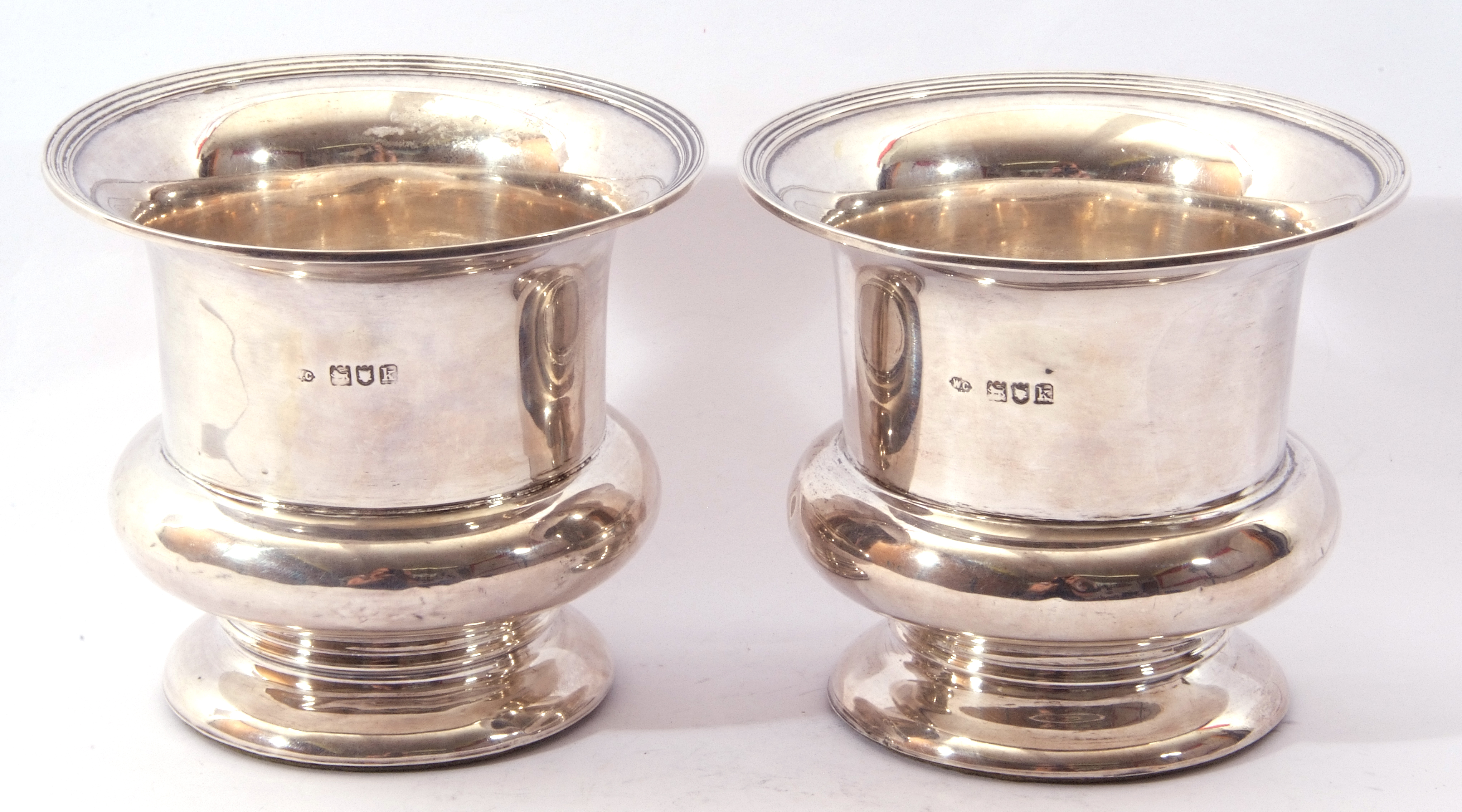 Pair of silver bottle holders of campana shape, plain polished form, reeded rims (loaded), hall