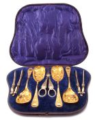 Victorian cased dessert serving set of silver plated and gilded berry spoons, nutcrackers, grape