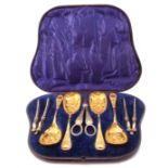 Victorian cased dessert serving set of silver plated and gilded berry spoons, nutcrackers, grape