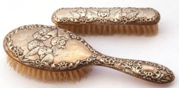 Mixed Lot: two silver backed dressing table brushes, both embossed with cherubs and scrolls etc,