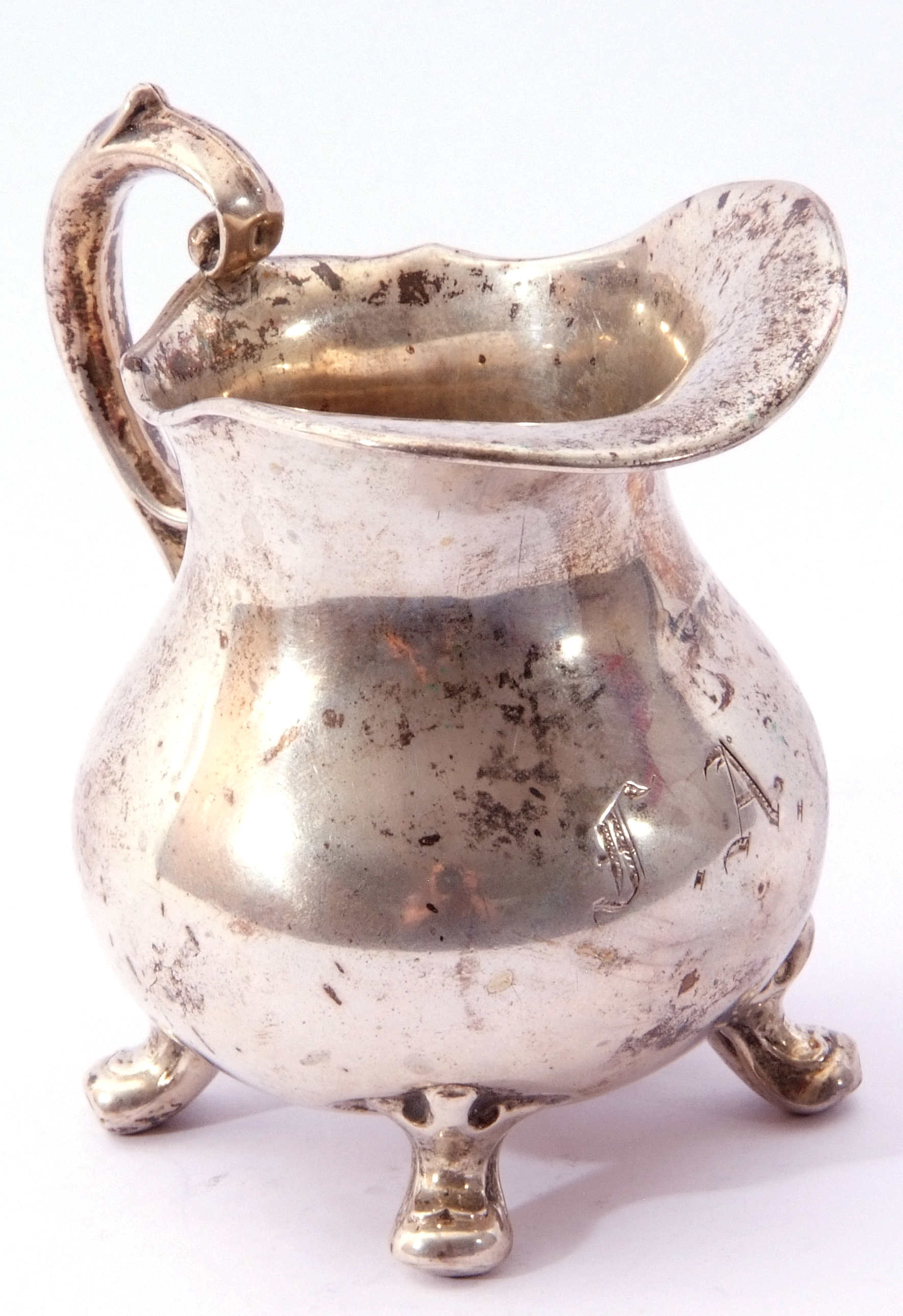 Continental white metal small cream jug of round bellied form with ornate scroll handle, capped