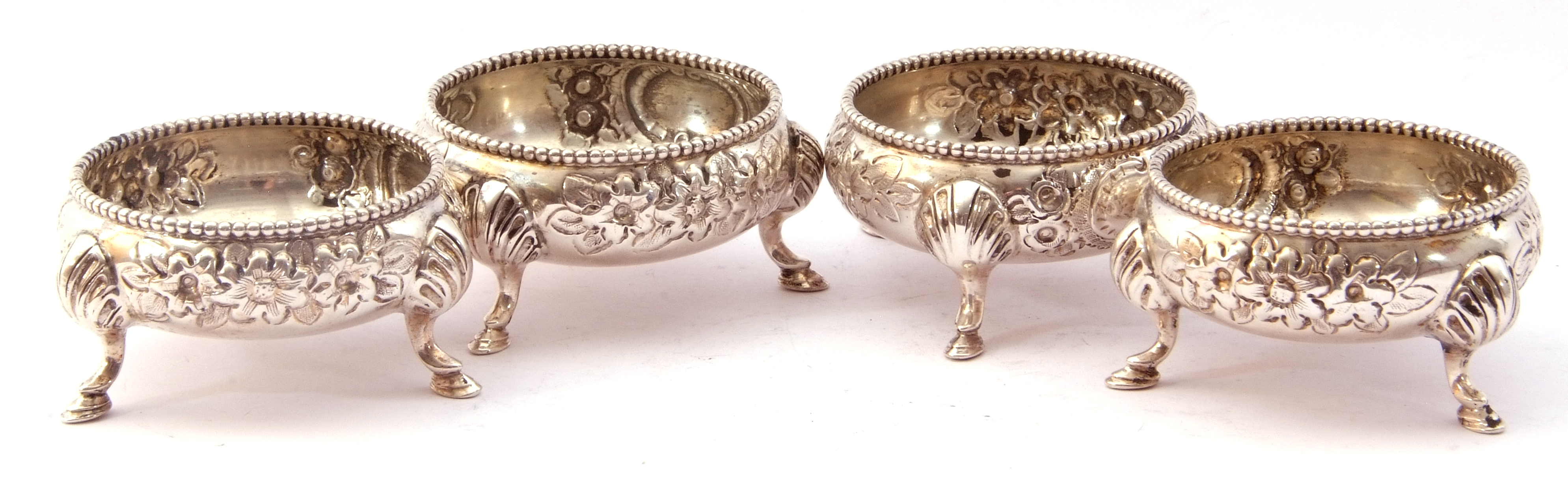 Late Victorian set of four cauldron salts each with gadrooned rims, foliate repousse decoration on